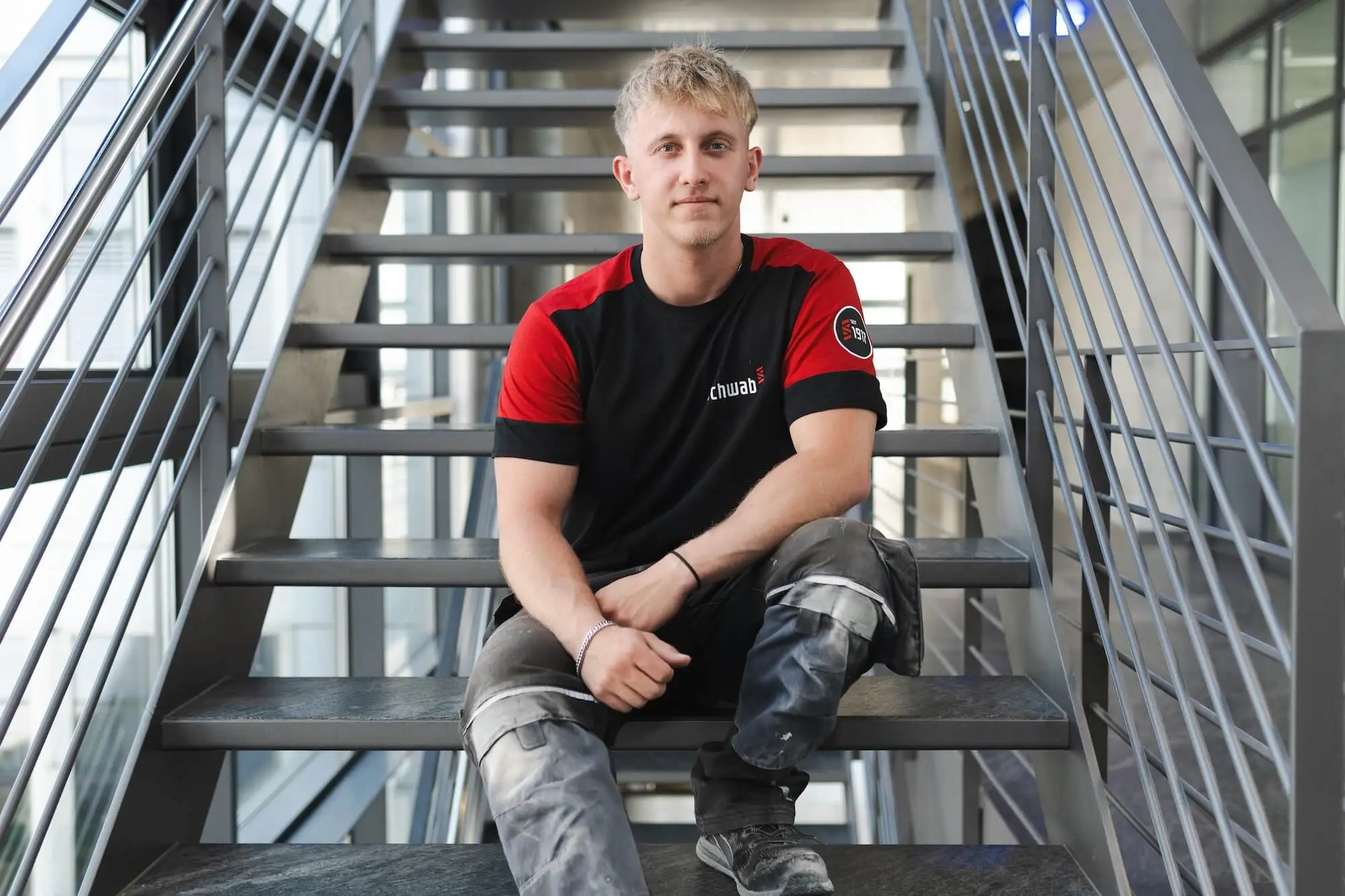 Mitarbeiter sitzt auf einer Stiege